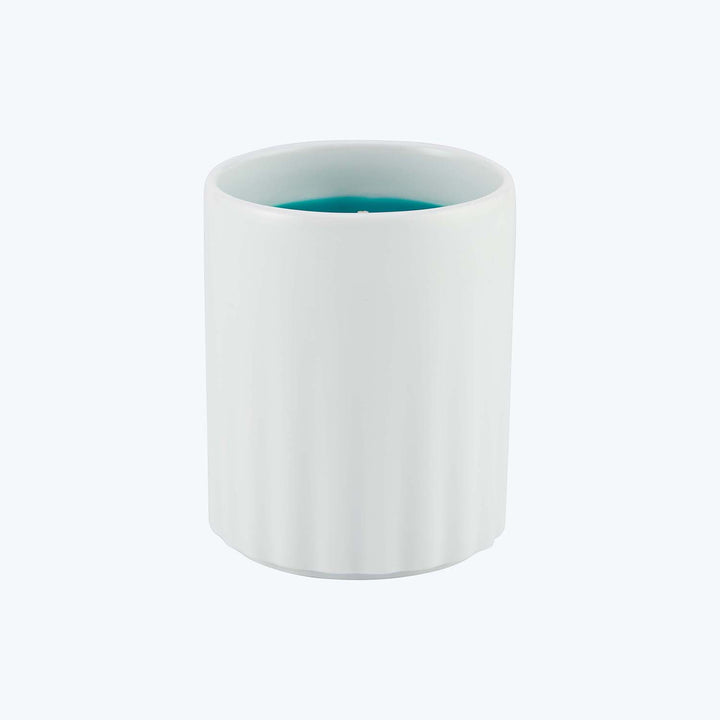 Smooth white candle with teal wax partially visible at top.