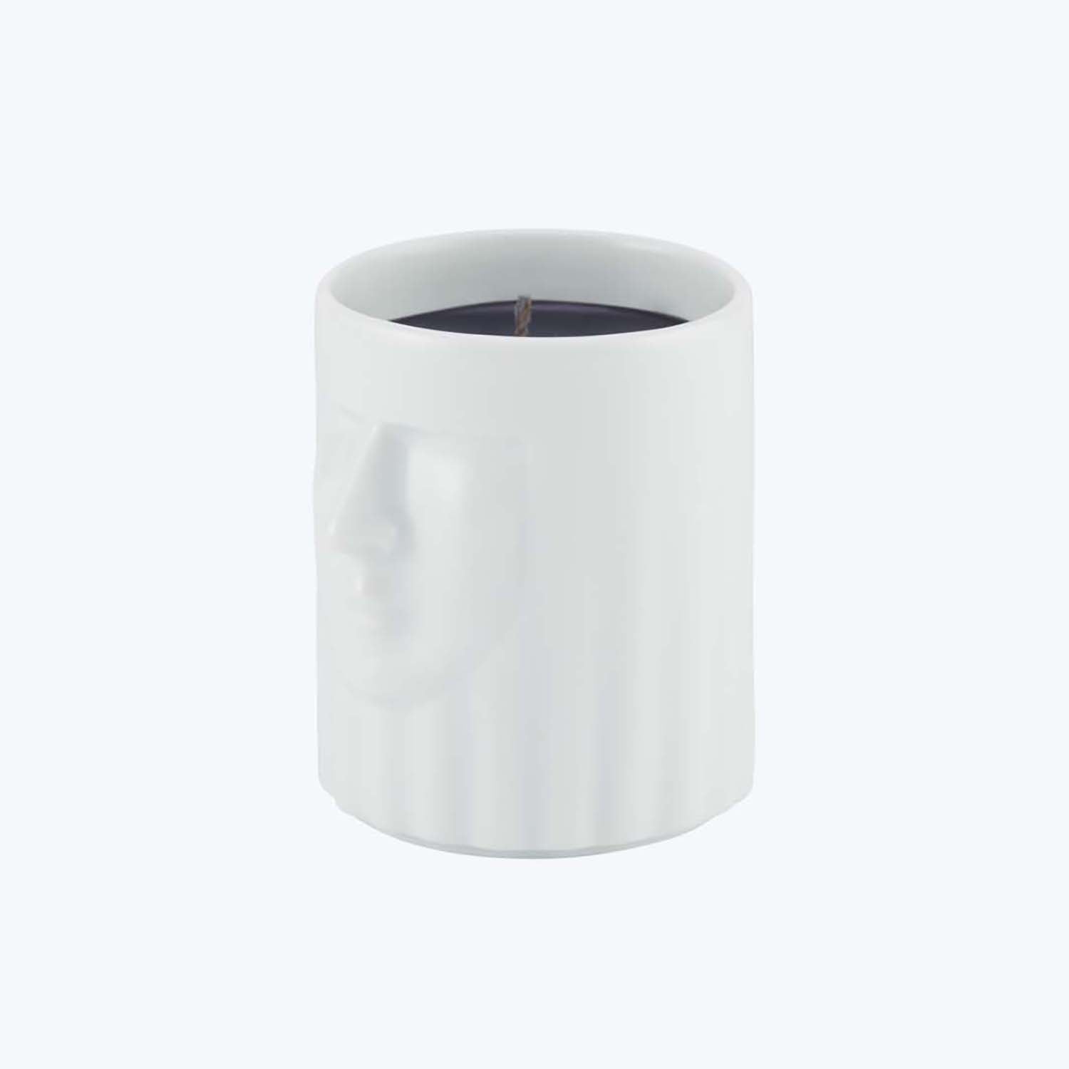 Unique white candle holder features sculptural face and contrasting wax.