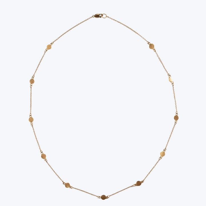 Delicate gold necklace with disc-shaped decorations on white background.