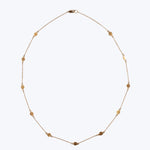 Delicate gold necklace with disc-shaped decorations on white background.