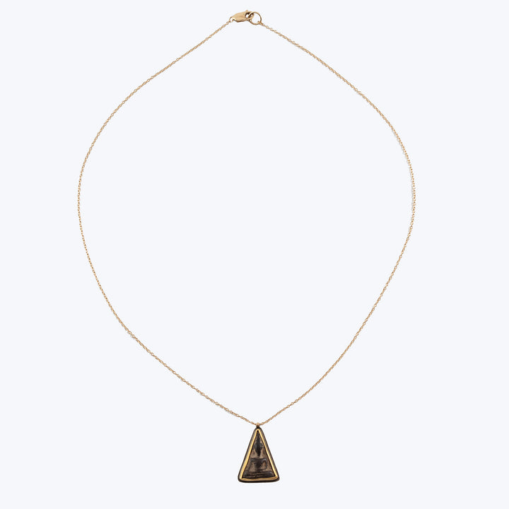 Gold-tone necklace with triangle pendant featuring dark mottled stone.