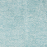 Close-up of teal dotted fabric with organic, speckled texture.