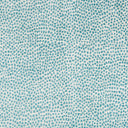 Close-up of teal dotted fabric with organic, speckled texture.