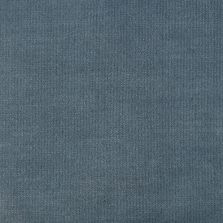 Close-up of medium blue denim fabric with twill weave texture.