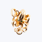 Gold pendant with intricate design and green gemstone accents.