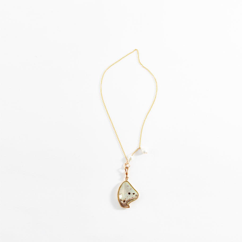 Delicate gold-tone necklace with marbled pendant, versatile for any occasion.