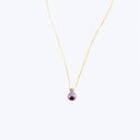 Exquisite gold necklace with iridescent purple pearl pendant shines elegantly.