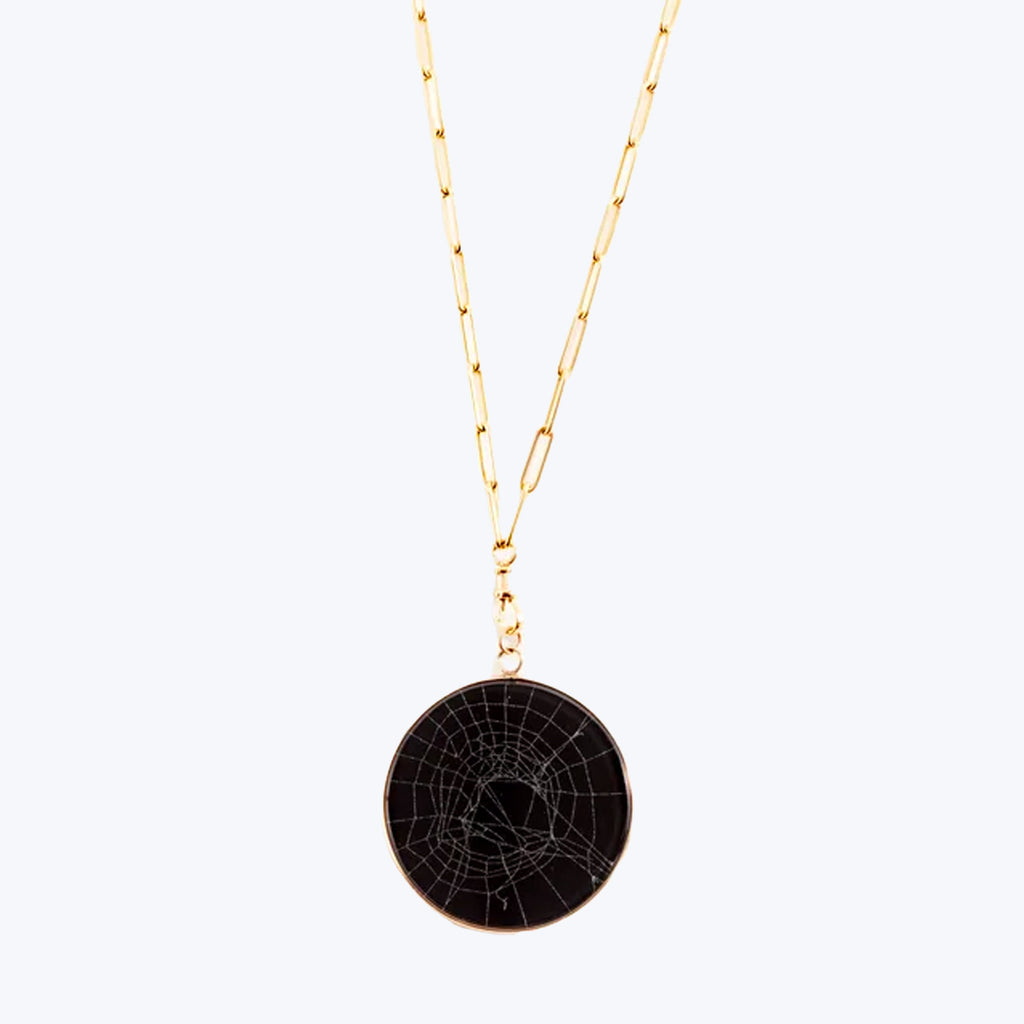 Gold necklace with spider web pendant, perfect for stylish elegance.