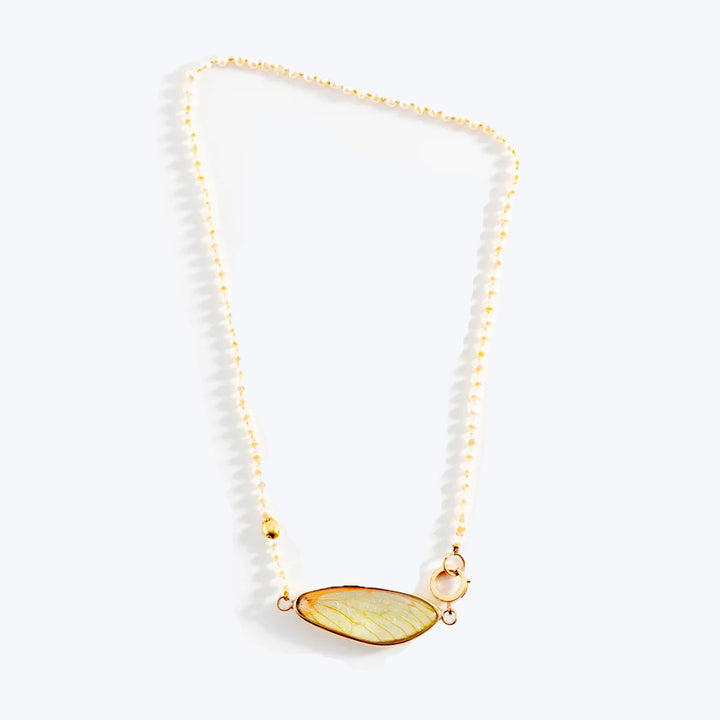 Dainty gold necklace with translucent pendant and delicate bead chain.