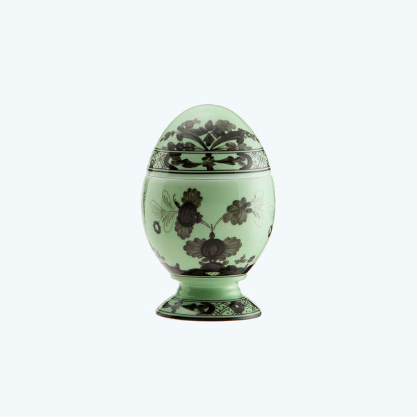 Decorative egg with intricate green floral pattern on matching stand.