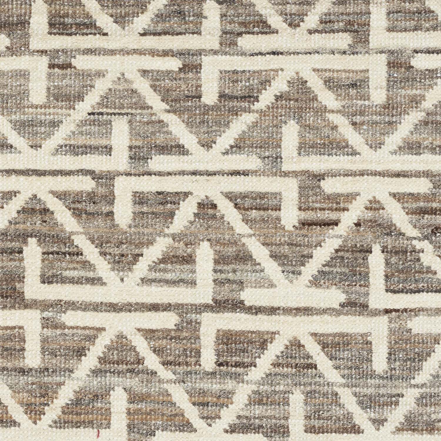 Close-up of a cream geometric patterned fabric or carpet texture.