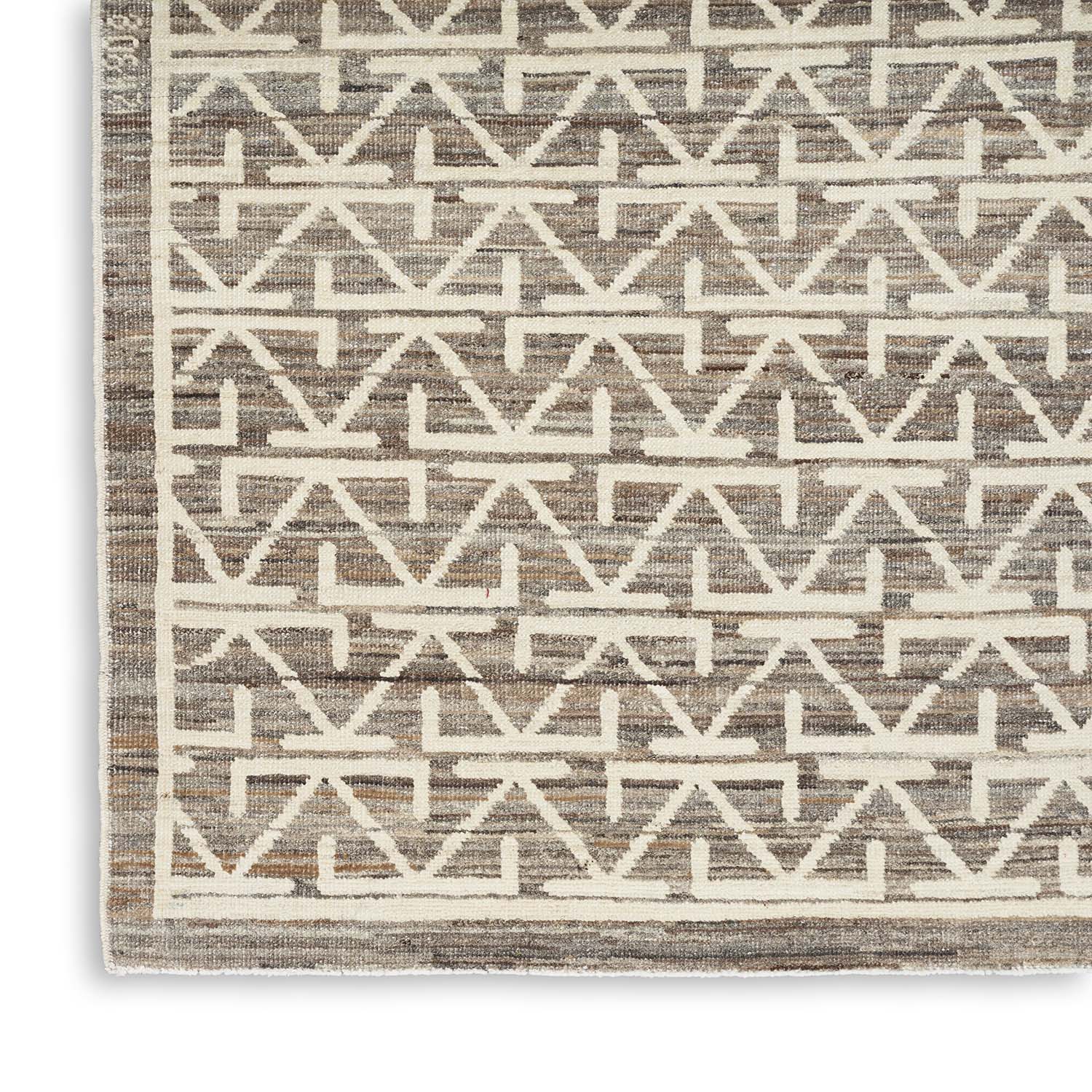 Close-up of a modern, geometric-patterned rug in neutral colors.