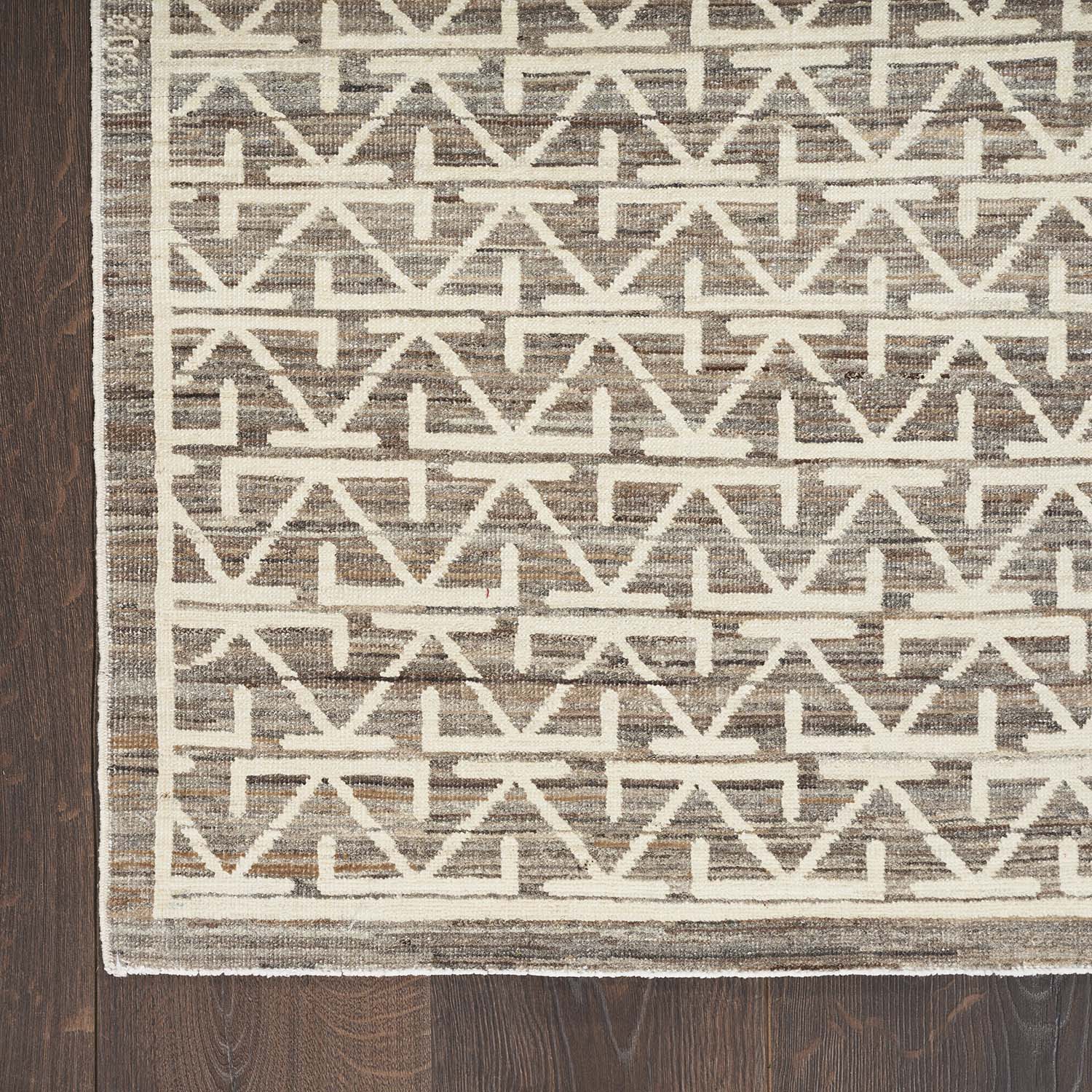 Geometric patterned rug adds elegance and style to wooden flooring.