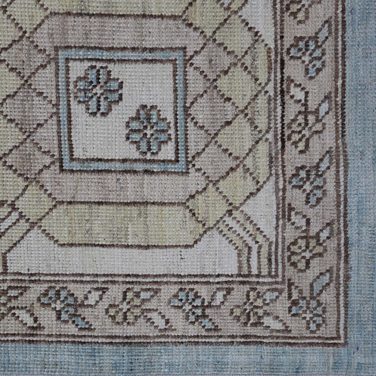 Intricate carpet with geometric shapes, floral motifs; earth-toned color palette.