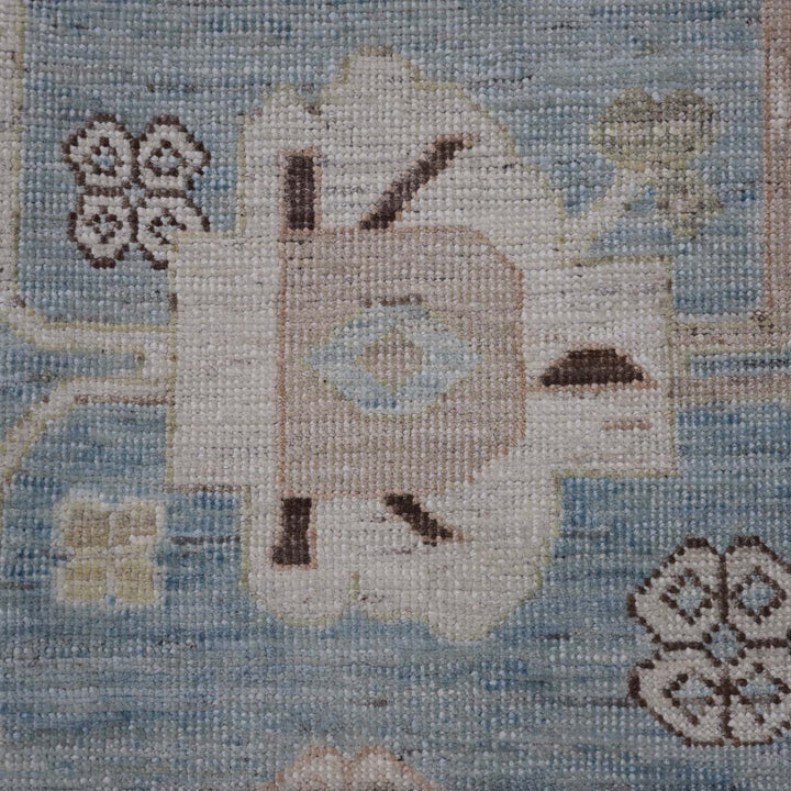 Close-up of textile with mosaic-like pattern, showcasing colors and shapes, including a stylized eye or abstract design.