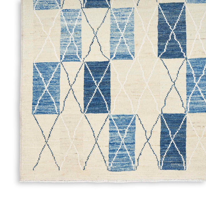 Contemporary rug with blue and white diamond pattern displays artisanal charm.
