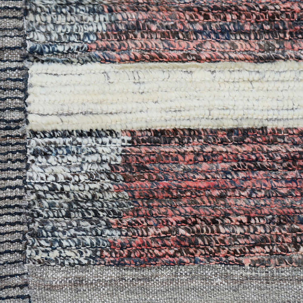 Close-up of textured fabric showcasing bands of varied colors and weaves.