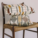 Colorful geometric patterned pillows adorning a vintage wooden chair.