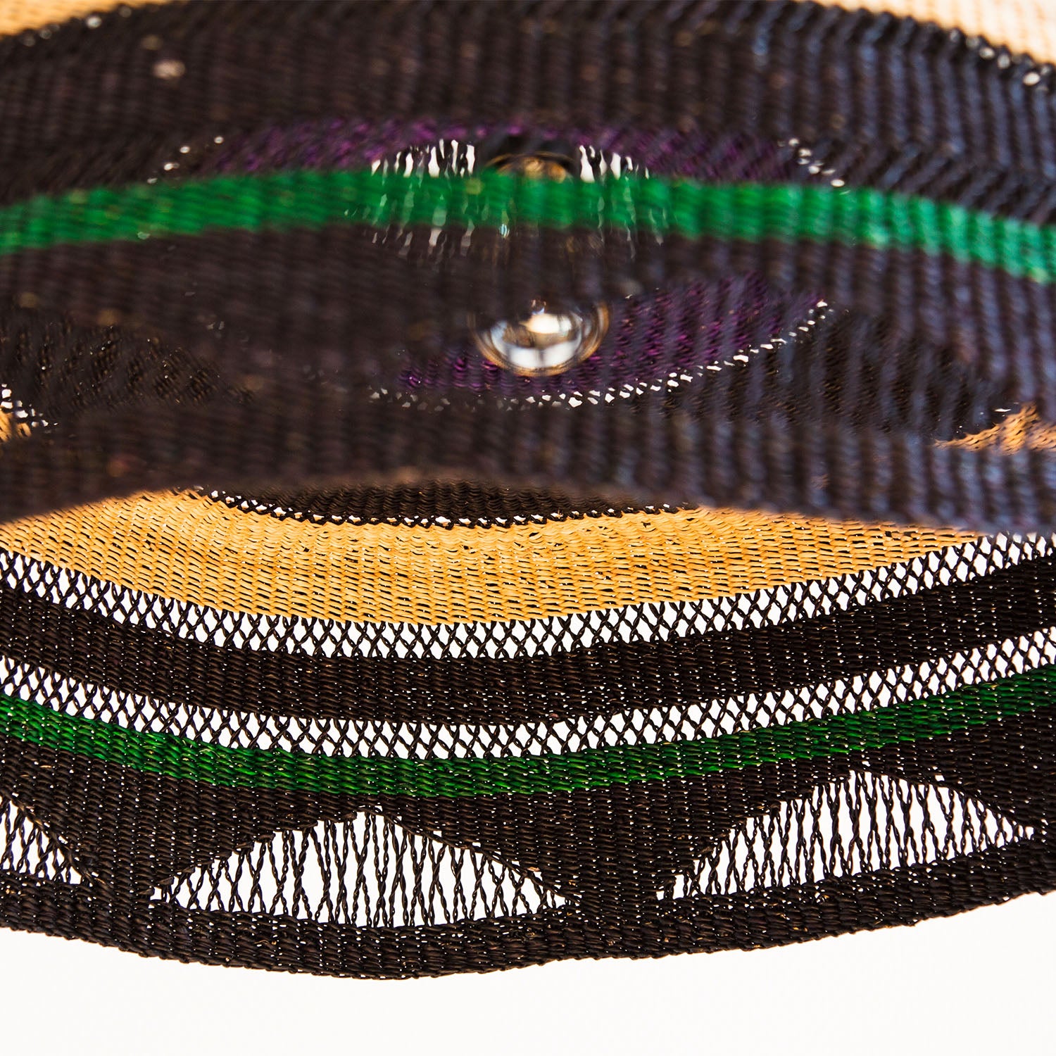 Close-up of a colorful, layered mesh fabric with water droplet