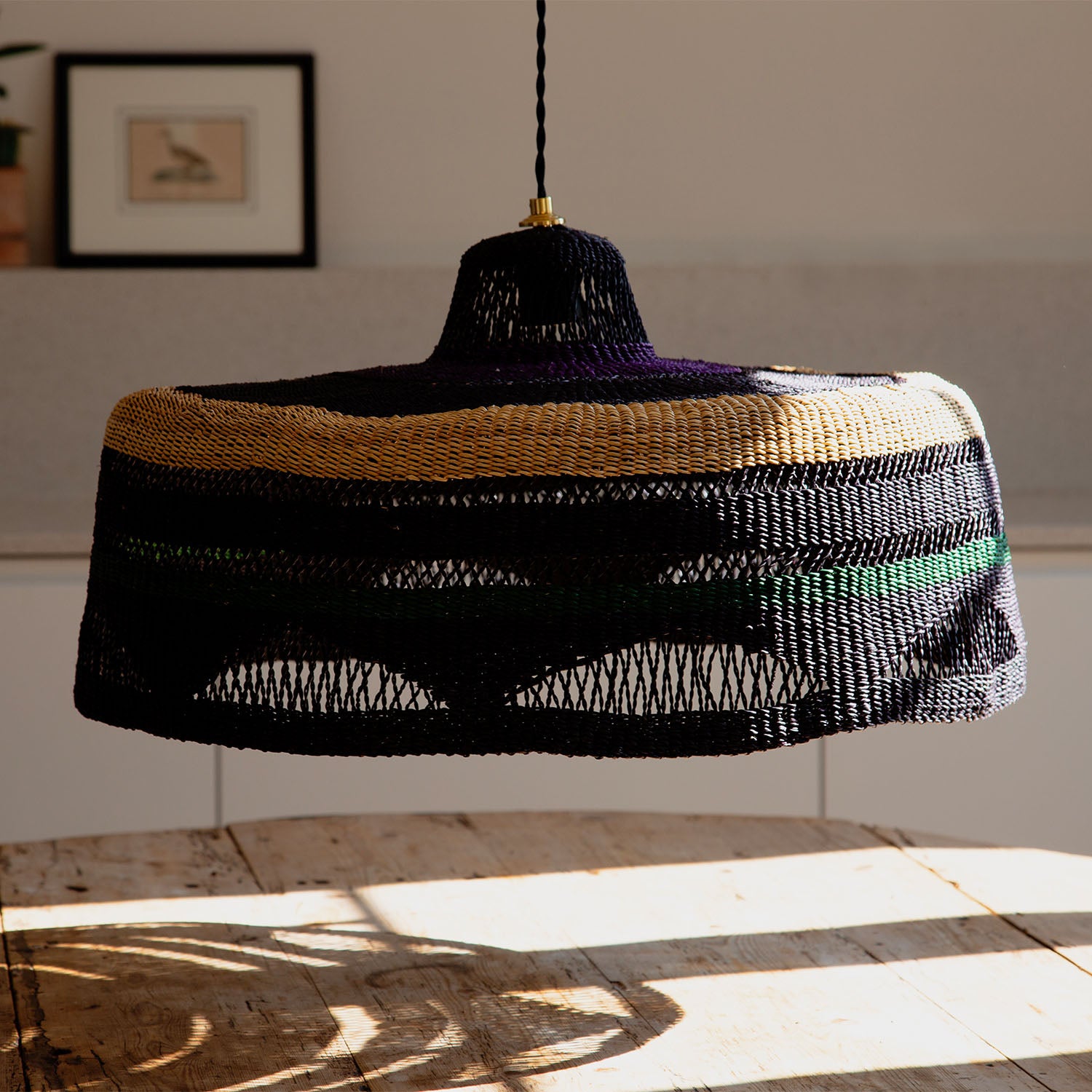 Stylish woven pendant light with colorful stripes adds warmth to room.
