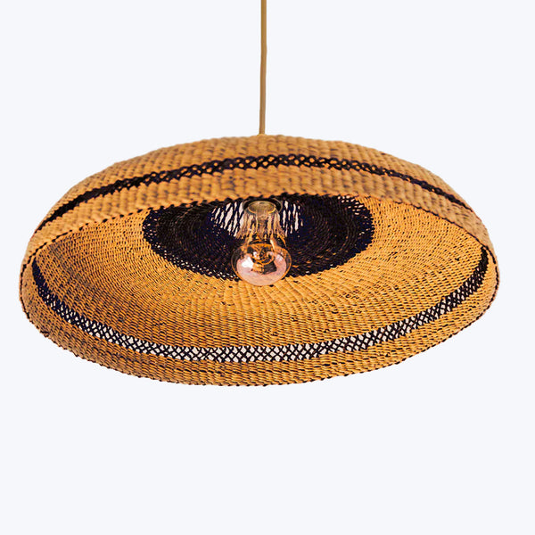 Intricate pendant lamp crafted from woven natural and black materials.