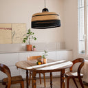 Cozy dining area with rustic table, pendant lamp, and artistic accents.