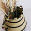 Artisanal handwoven basket showcasing a rustic dried plant arrangement