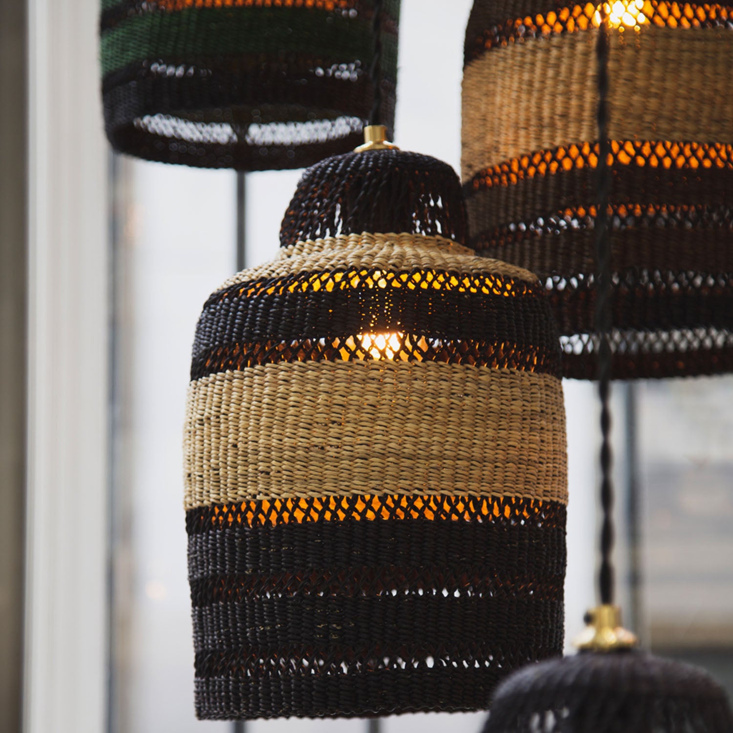 Multiple pendant lights made from woven materials create an inviting atmosphere.