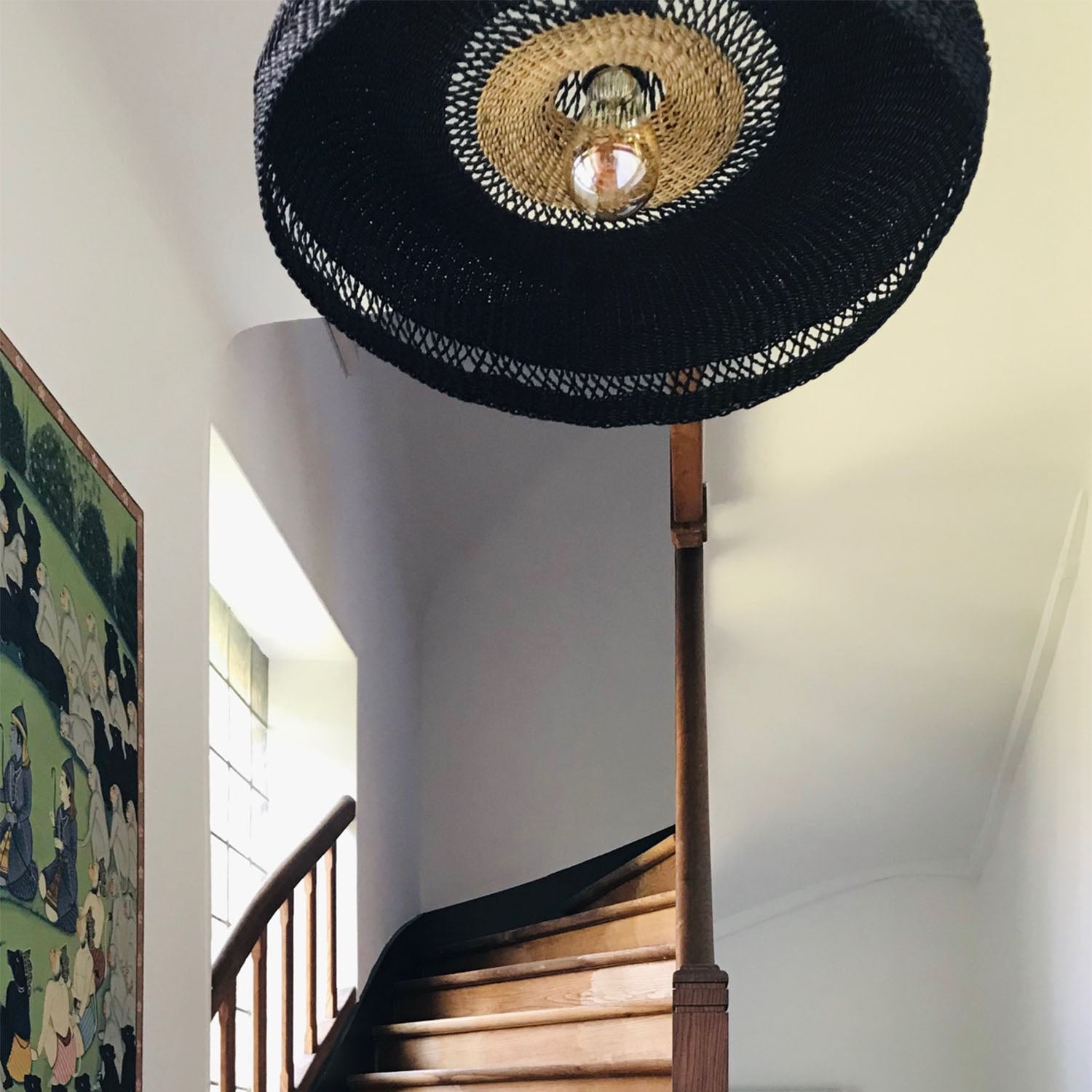 Artfully designed staircase with a whimsical hat lampshade fixture above