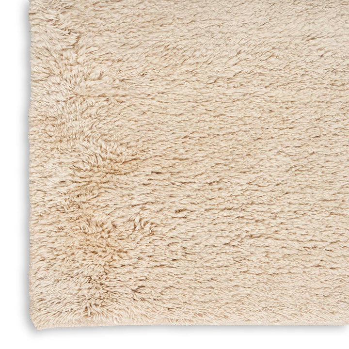 Plush cream-colored rug with soft, shaggy texture against white background.