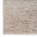 Close-up of a luxurious shaggy rug in neutral tones.