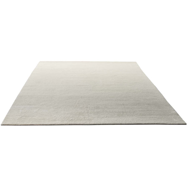 Minimalistic light-colored rug with a smooth texture on white background