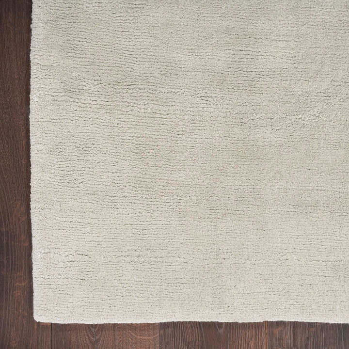 Textured cream rug with soft shaggy fibers and slight discoloration.