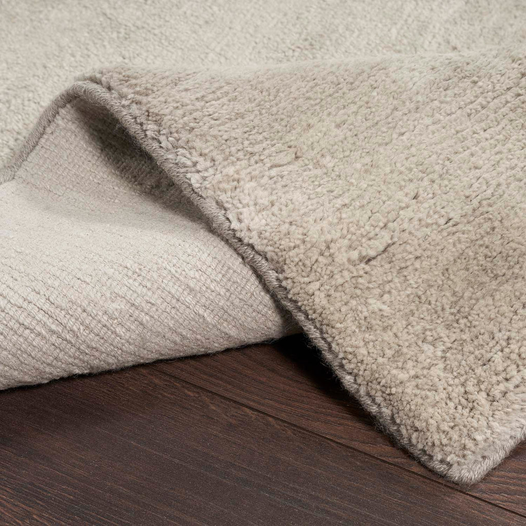 Close-up of soft plush fabric with a fold on wooden floor.