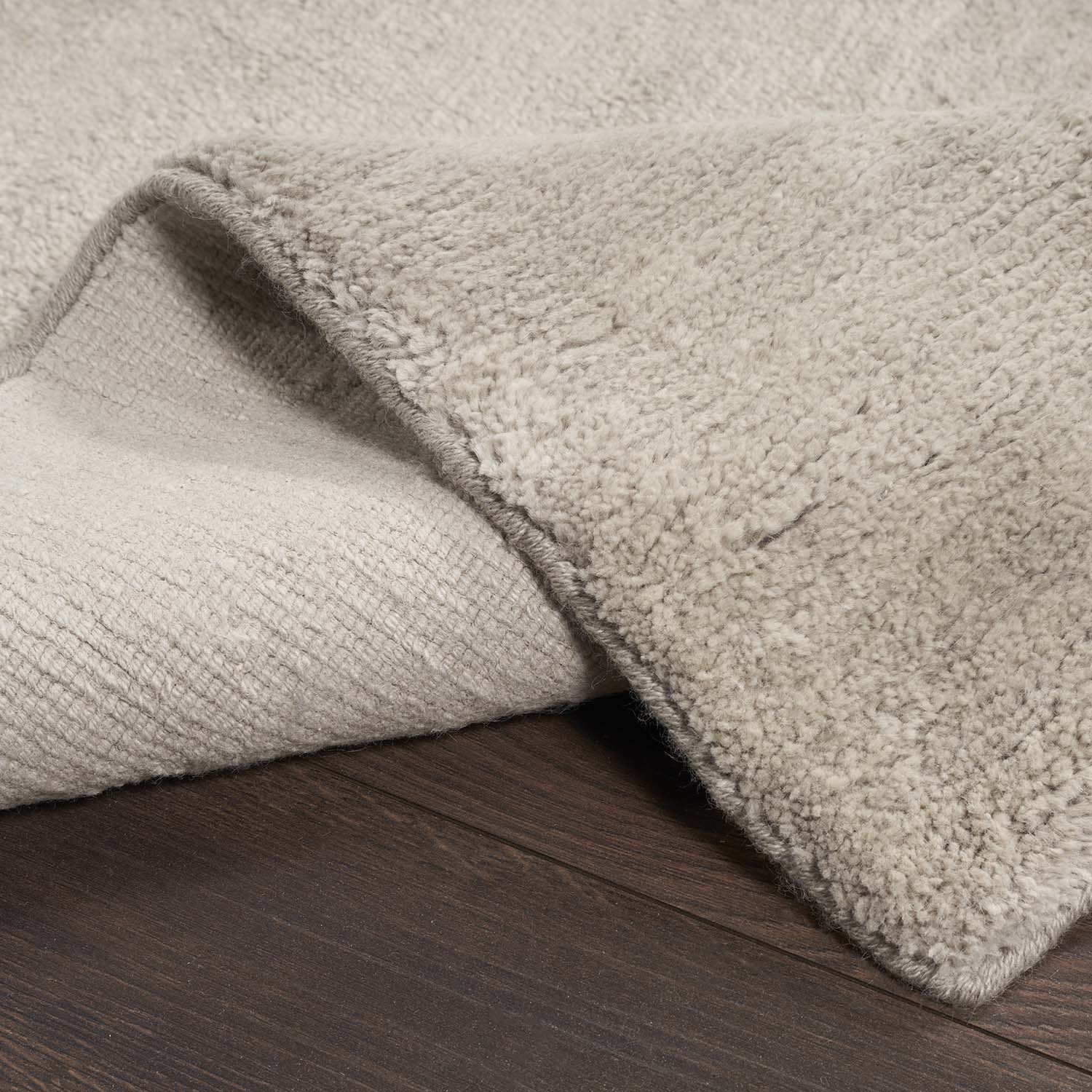 Close-up of soft plush fabric with a fold on wooden floor.