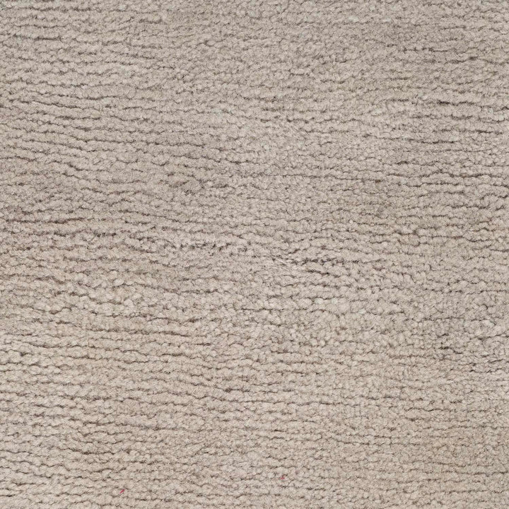 Close-up of a light grey, textured carpet after cleaning