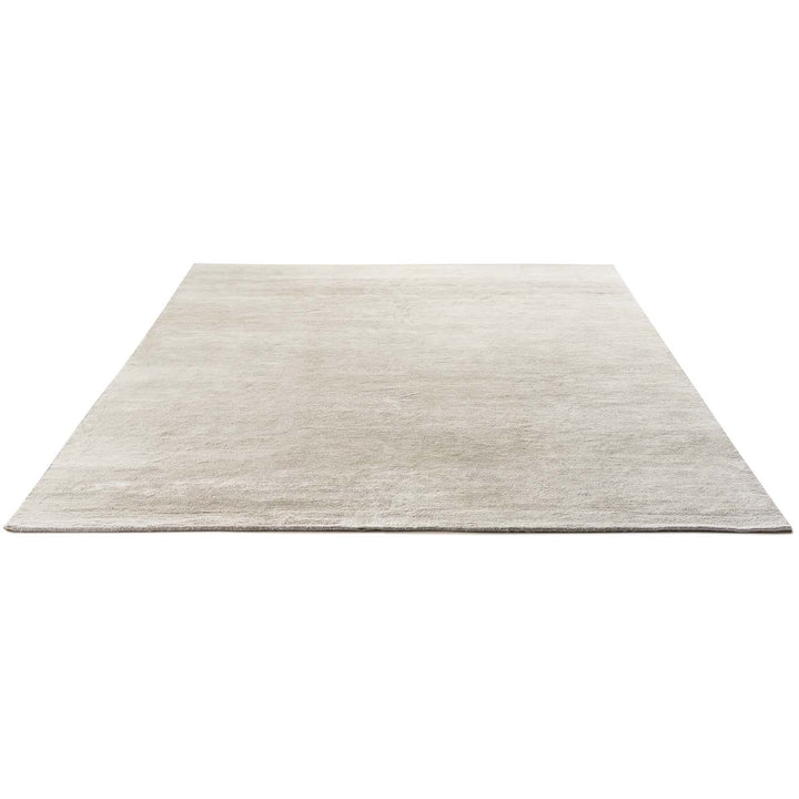 Minimalist solid-colored area rug with subtle gradient and soft texture.
