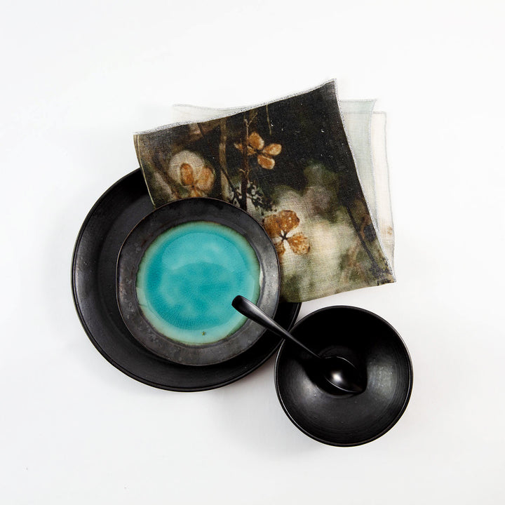 Contemporary still life setting featuring abstract dishware and floral print