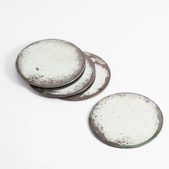 Set of four artisanal ceramic coasters with rustic, speckled design.