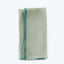 Neatly folded light green fabric with blue stitch detail.