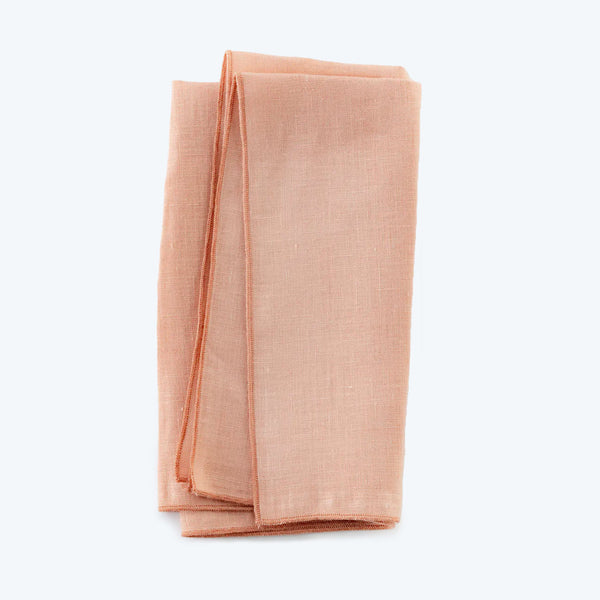 Neatly folded light pink linen fabric, freshly laundered and smooth.