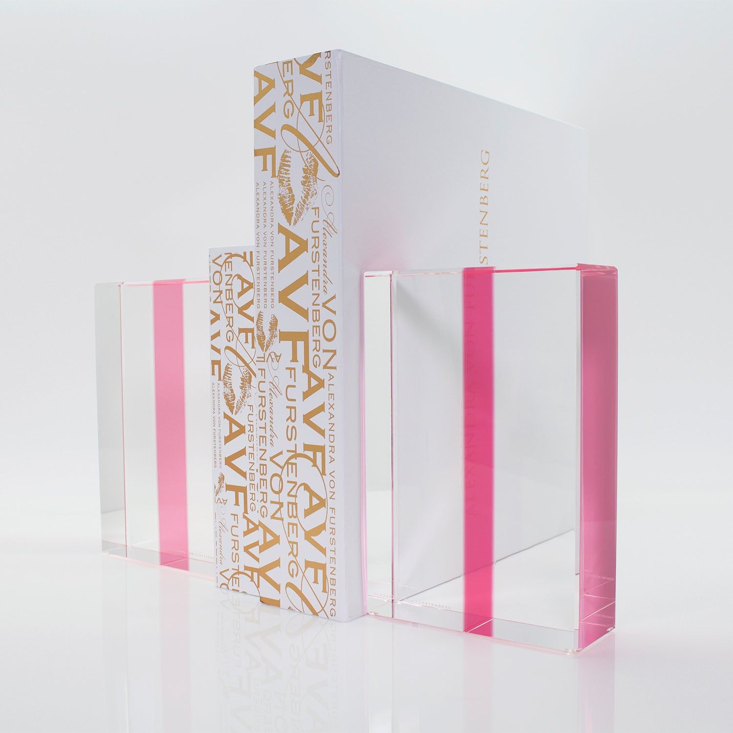 Four pink-tinted translucent books in ascending size order with reflective surfaces.