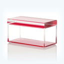 Modern minimalist coffee table with transparent construction and vibrant red border.