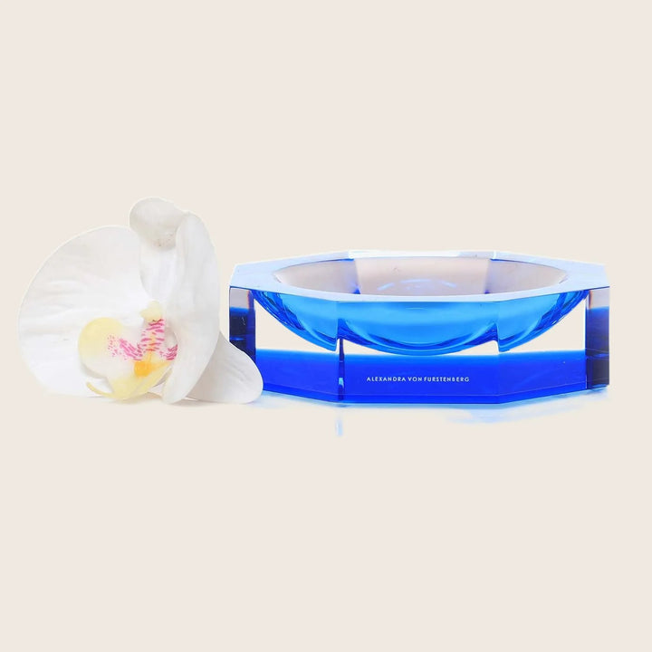 Vibrant blue ashtray with geometric design and elegant orchid flower.
