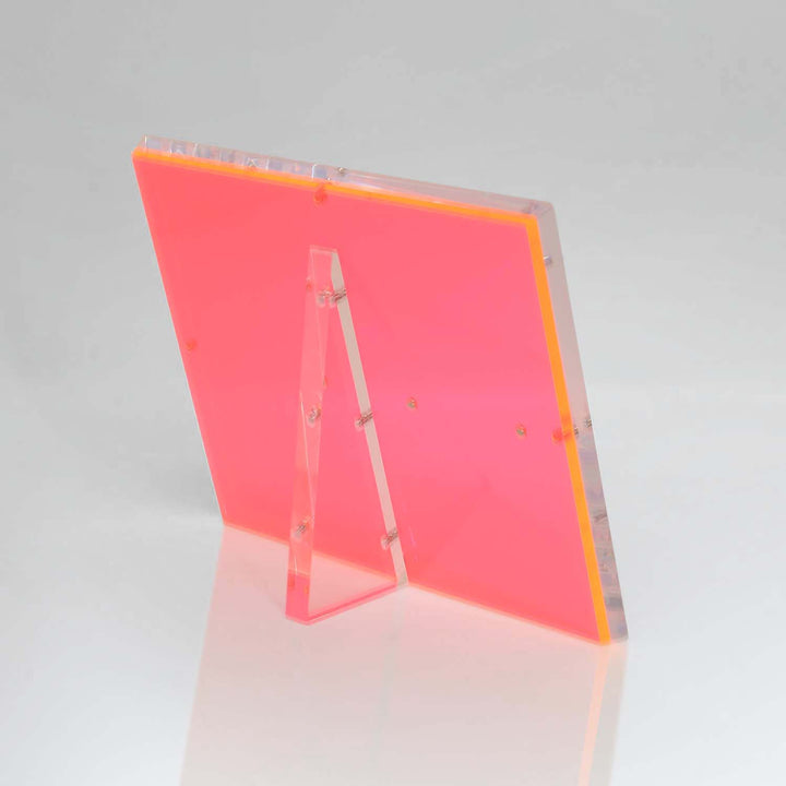 Vibrant red acrylic table tent sign holder against grey background.