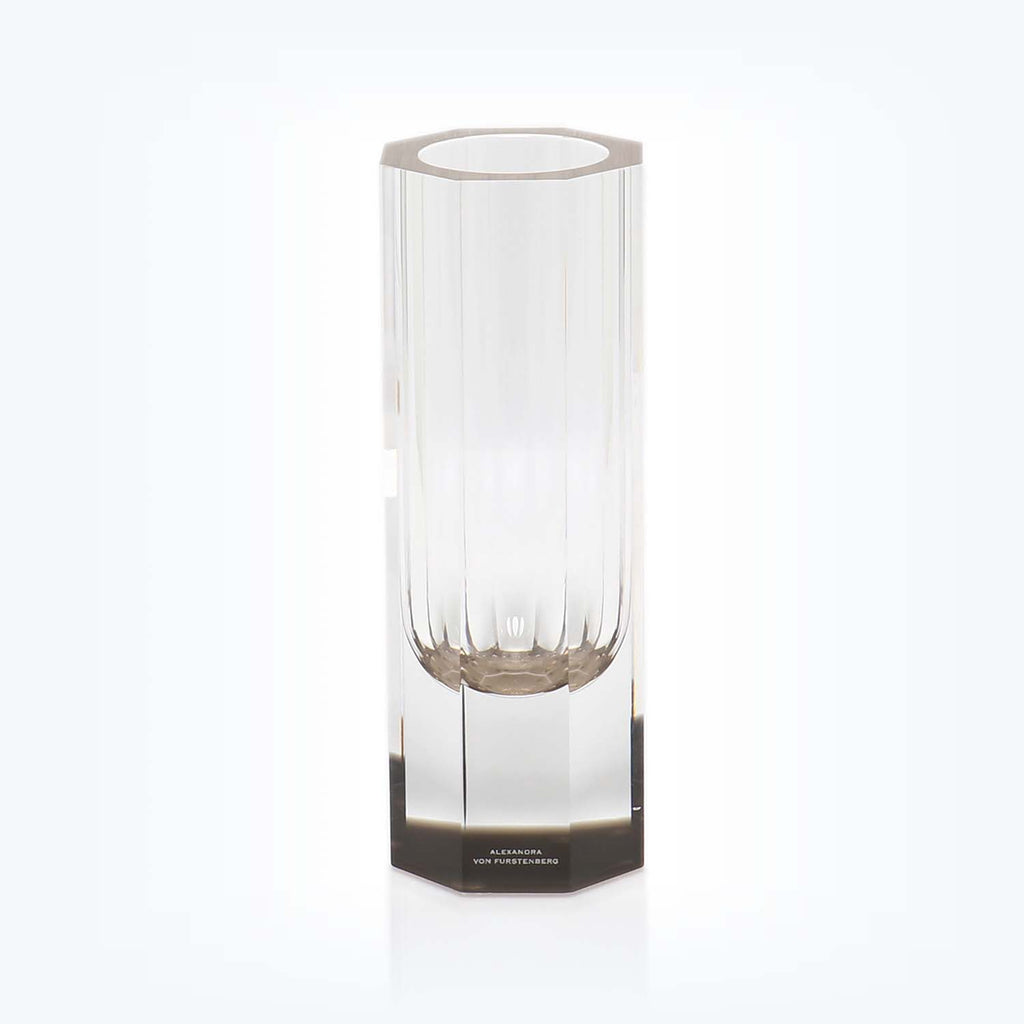 Elegant, modern glass vase on reflective base, brand name displayed.