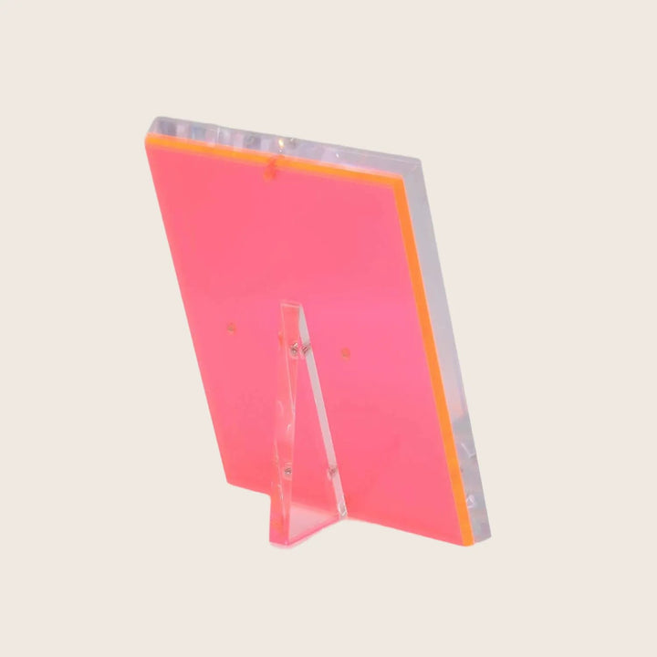Vibrant neon pink acrylic stand shines against gradient white background.