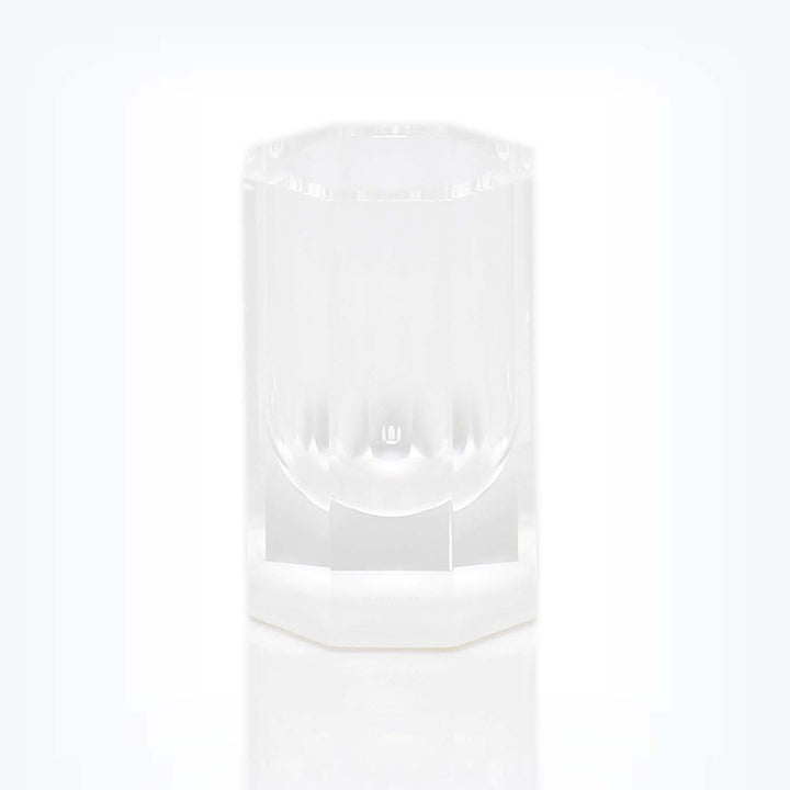 Minimalist clear plastic cup with ribbed design on white base.
