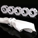 Geometric napkin rings on reflective surface, contrasting white against black.