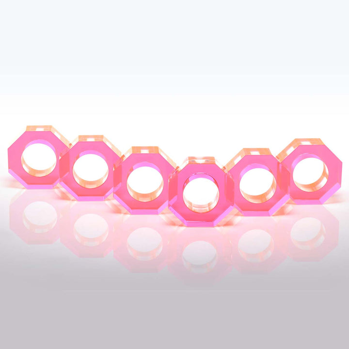 Row of pink hexagonal nuts with threaded central holes on glossy surface.